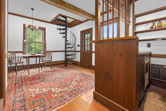 interior space featuring a notable chandelier, beam ceiling, a healthy amount of sunlight, and hardwood / wood-style flooring