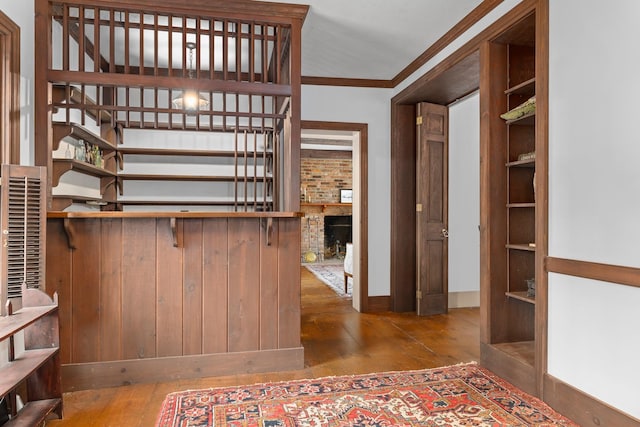 walk in closet with wood-type flooring and a brick fireplace