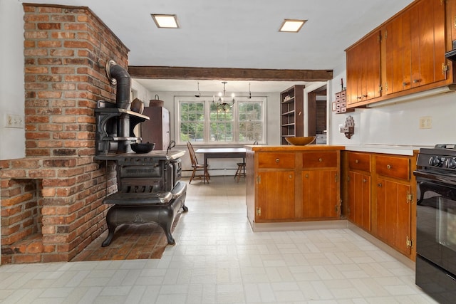 kitchen with light tile flooring, beam ceiling, black stove, a wood stove, and an inviting chandelier