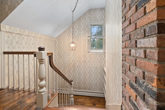 staircase with wood-type flooring, a baseboard radiator, and vaulted ceiling