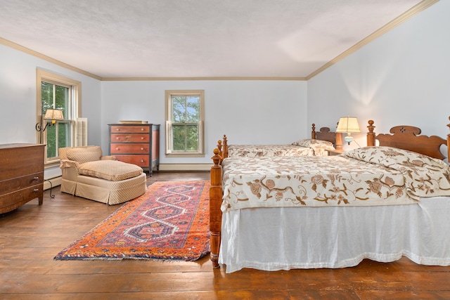 bedroom with hardwood / wood-style flooring, crown molding, and baseboard heating