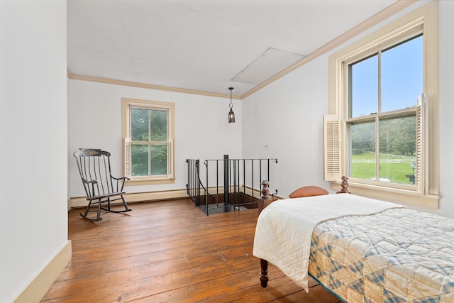 bedroom with ornamental molding, hardwood / wood-style flooring, and baseboard heating