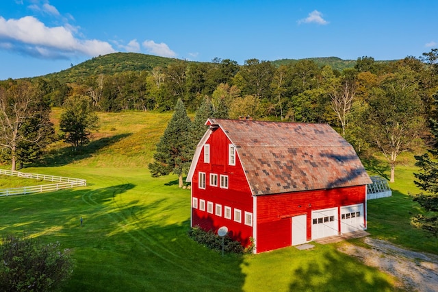 view of shed / structure with a mountain view, a lawn, and a garage