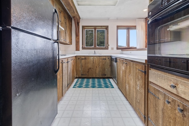 kitchen featuring stainless steel dishwasher, sink, light tile floors, and black fridge