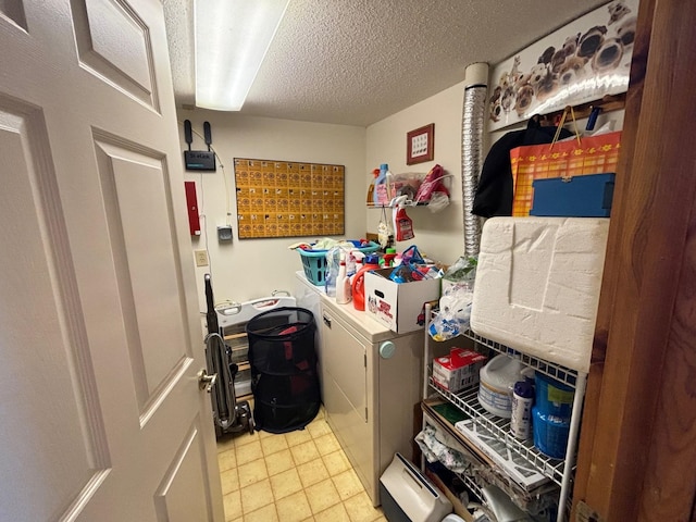 laundry area with a textured ceiling and washer and clothes dryer