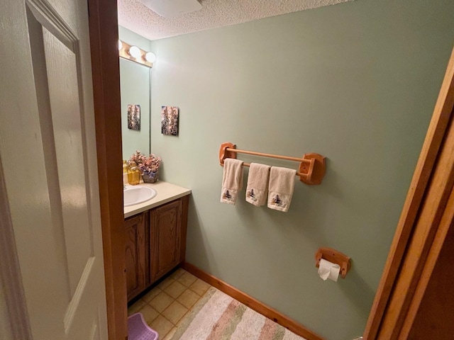 bathroom with vanity, a textured ceiling, and tile patterned flooring