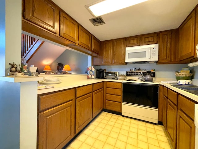 kitchen featuring white appliances and kitchen peninsula