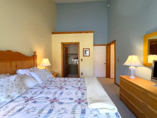 carpeted bedroom featuring a closet and a towering ceiling