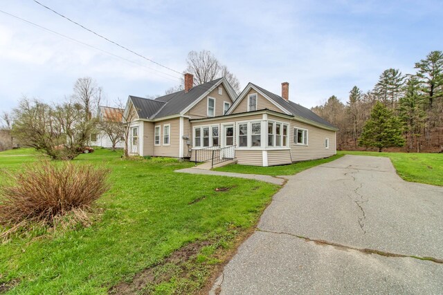 view of front of property with a front yard and a sunroom