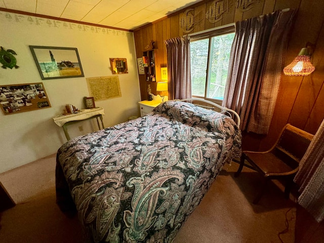 bedroom featuring wood walls and carpet