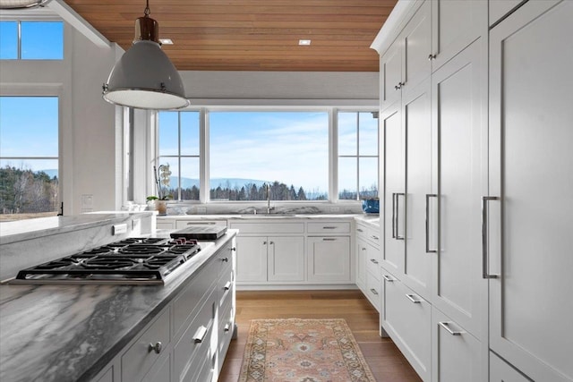 kitchen featuring light wood-style floors, a sink, wood ceiling, and stainless steel gas cooktop