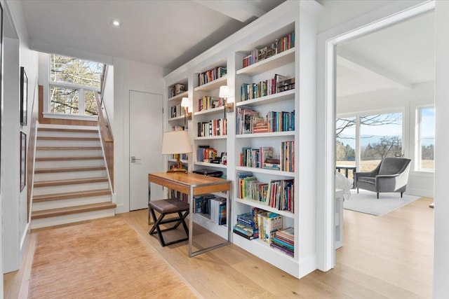 living area with stairway, built in shelves, plenty of natural light, and light wood-style floors