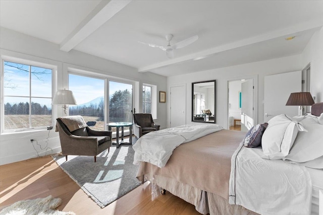 bedroom with baseboards, wood finished floors, a ceiling fan, and beamed ceiling