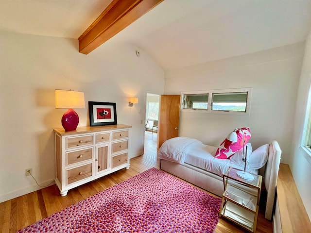 bedroom featuring baseboards, wood finished floors, and lofted ceiling with beams