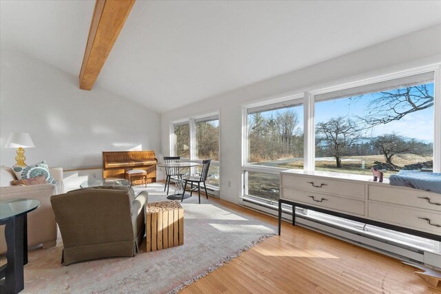 living room featuring wood finished floors, a baseboard heating unit, and vaulted ceiling with beams