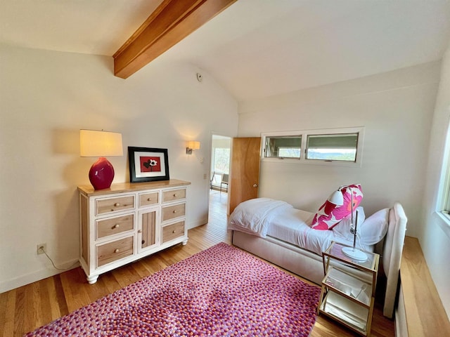 bedroom with baseboards, lofted ceiling with beams, and wood finished floors