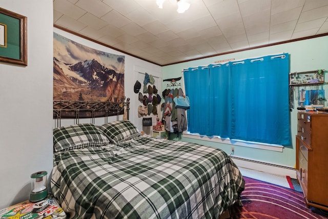 bedroom featuring baseboard heating and crown molding