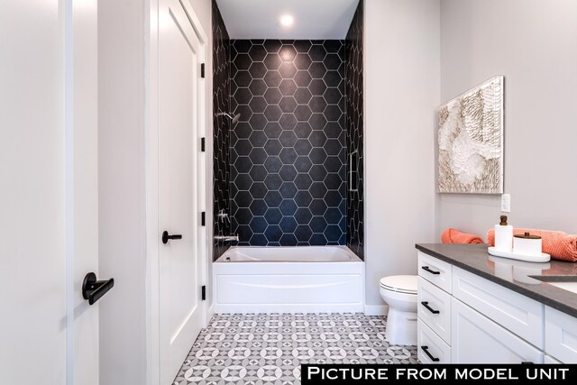 full bathroom with tile flooring, vanity, tiled shower / bath combo, and toilet
