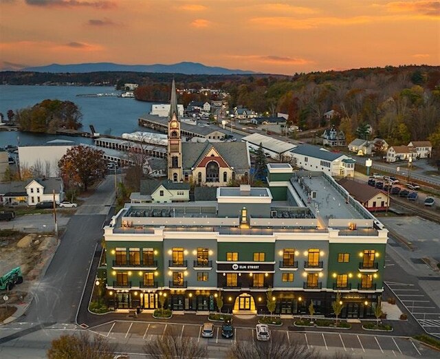 aerial view at dusk featuring a water and mountain view