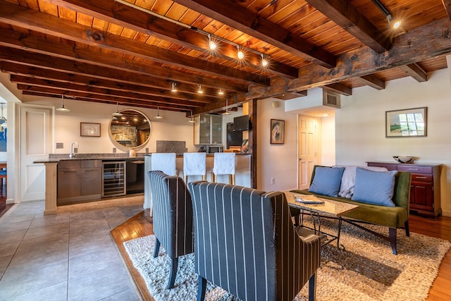 living room featuring beam ceiling, wooden ceiling, tile flooring, and beverage cooler