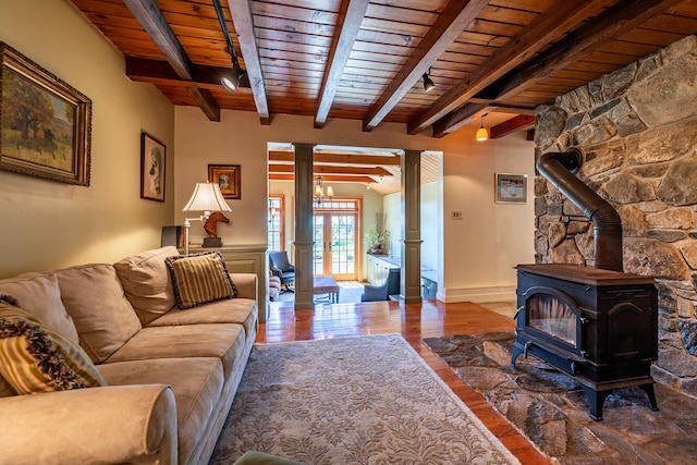 living room featuring wood-type flooring, a wood stove, beam ceiling, and wood ceiling