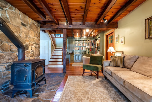 living room with beam ceiling, hardwood / wood-style floors, a wood stove, and wood ceiling