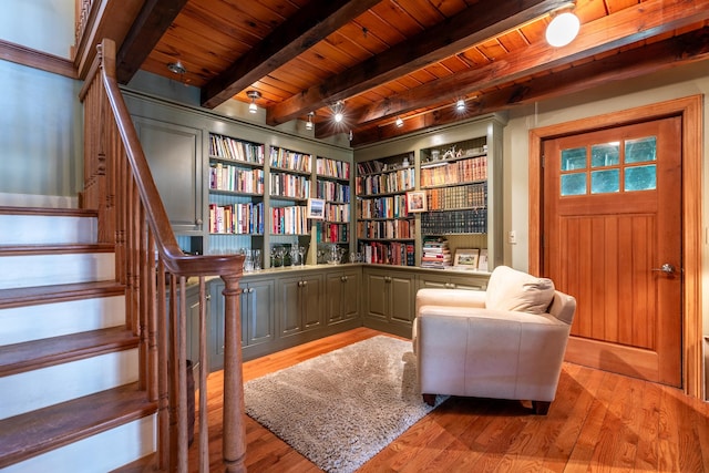 sitting room featuring built in features, beam ceiling, hardwood / wood-style flooring, and wood ceiling