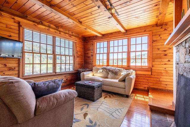 living room with beam ceiling, wood ceiling, plenty of natural light, and hardwood / wood-style floors