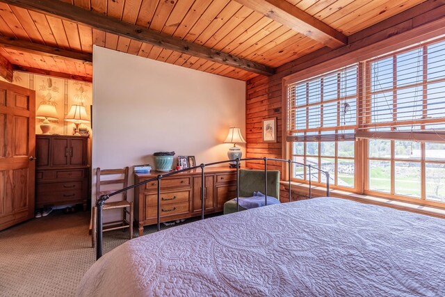 bedroom featuring wooden walls, lofted ceiling with beams, carpet flooring, and wooden ceiling