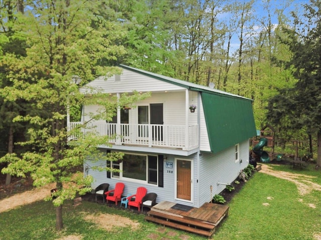 view of front of house with a front lawn and a balcony