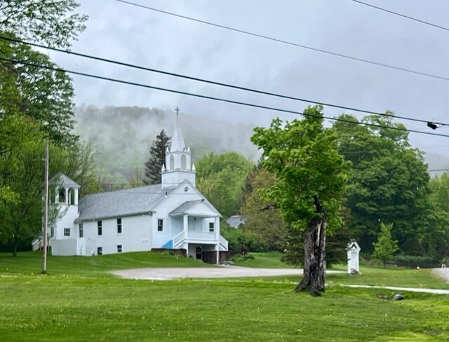 rear view of property featuring a lawn