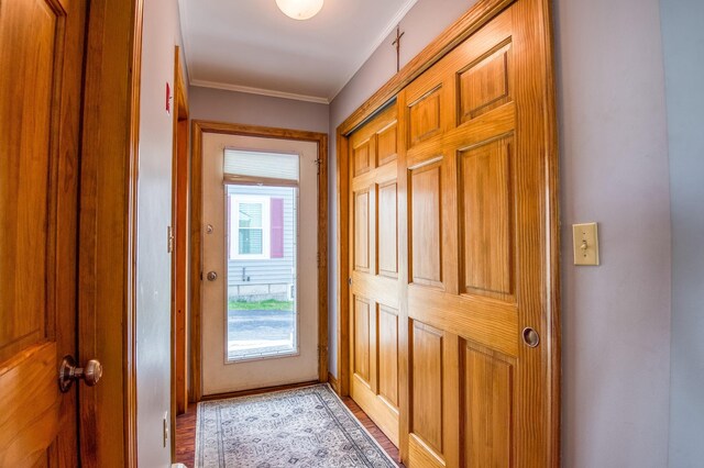 doorway to outside with crown molding and light hardwood / wood-style flooring