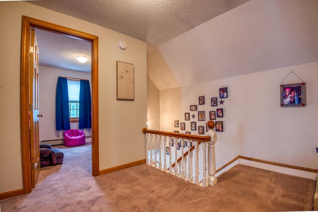 corridor with carpet flooring, a baseboard heating unit, a textured ceiling, and lofted ceiling