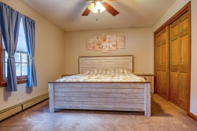 bedroom with a baseboard radiator, carpet flooring, and a closet