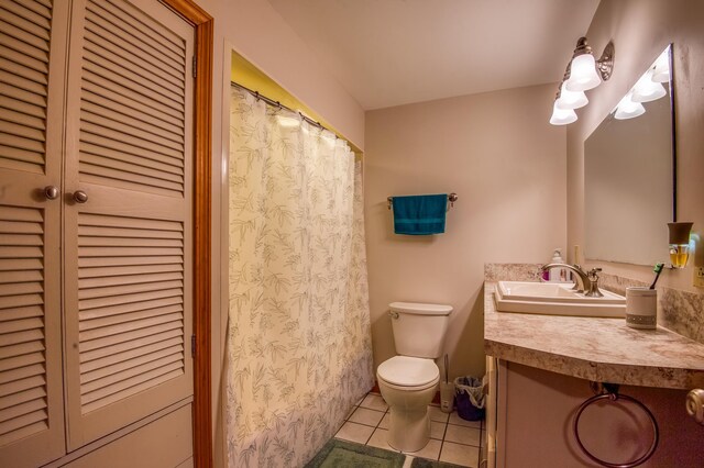 bathroom featuring tile flooring, vanity with extensive cabinet space, and toilet