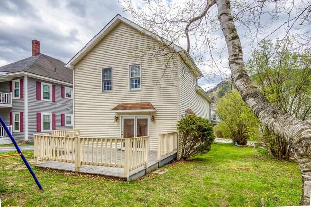 back of house with a yard and a deck