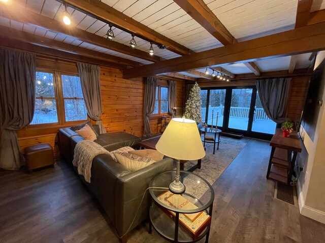 interior space featuring beamed ceiling, access to outside, dark hardwood / wood-style floors, wood walls, and rail lighting