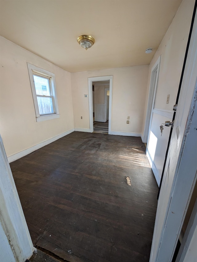 unfurnished room with dark hardwood / wood-style flooring