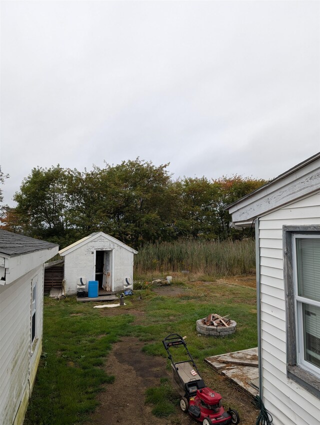 view of yard featuring a shed and an outdoor fire pit