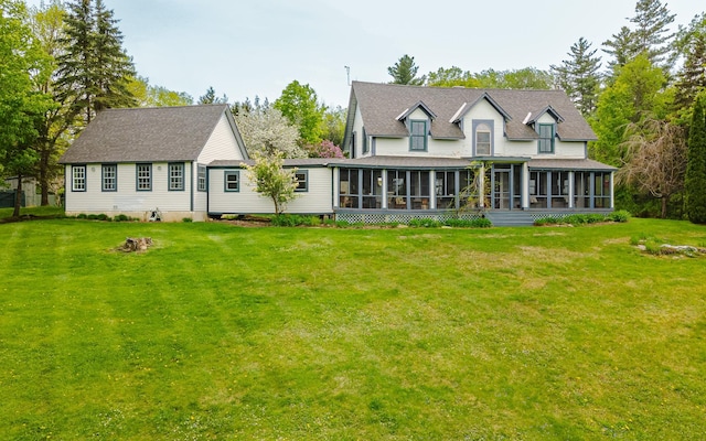 back of property with a yard and a sunroom