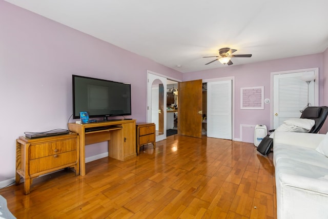 living room with ceiling fan and light hardwood / wood-style flooring