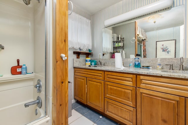 bathroom with tile flooring, oversized vanity, double sink, and shower / washtub combination