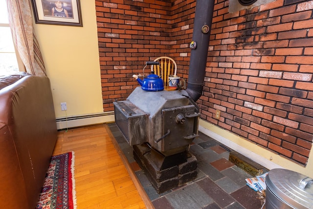 interior details featuring baseboard heating, hardwood / wood-style flooring, and a wood stove