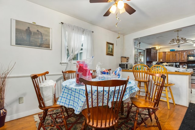 dining area with light hardwood / wood-style floors and ceiling fan