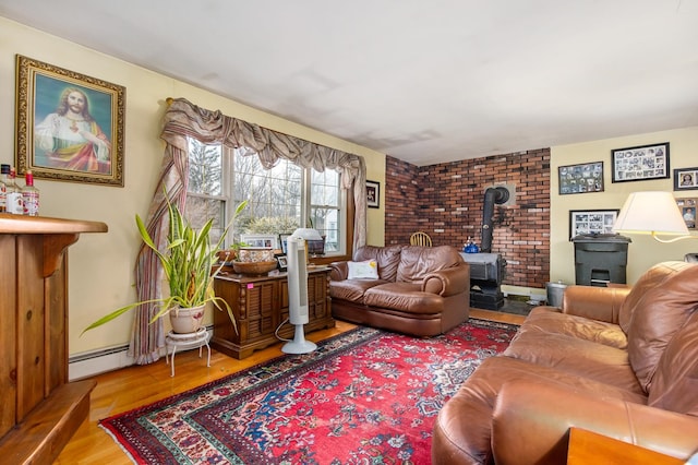 living room featuring baseboard heating, wood-type flooring, and a wood stove