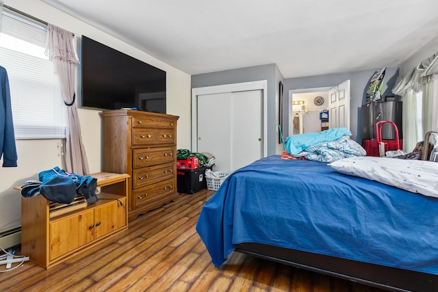 bedroom featuring refrigerator, a closet, and hardwood / wood-style flooring