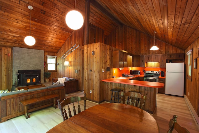 dining room featuring wooden ceiling, wood walls, a fireplace, and light wood finished floors