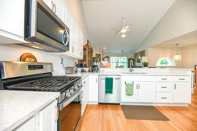 kitchen featuring white cabinets, light hardwood / wood-style floors, stainless steel appliances, and vaulted ceiling