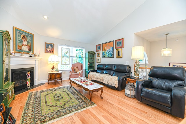 living room featuring vaulted ceiling and light hardwood / wood-style flooring