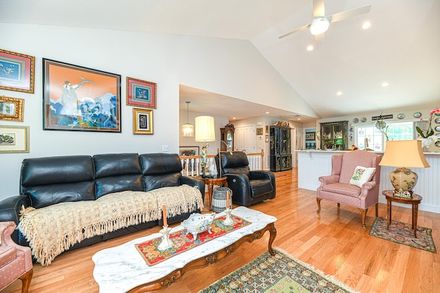 living room featuring ceiling fan, light hardwood / wood-style floors, and lofted ceiling